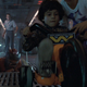 A curly-haired kid bikes down a futuristic hall while his family watches.